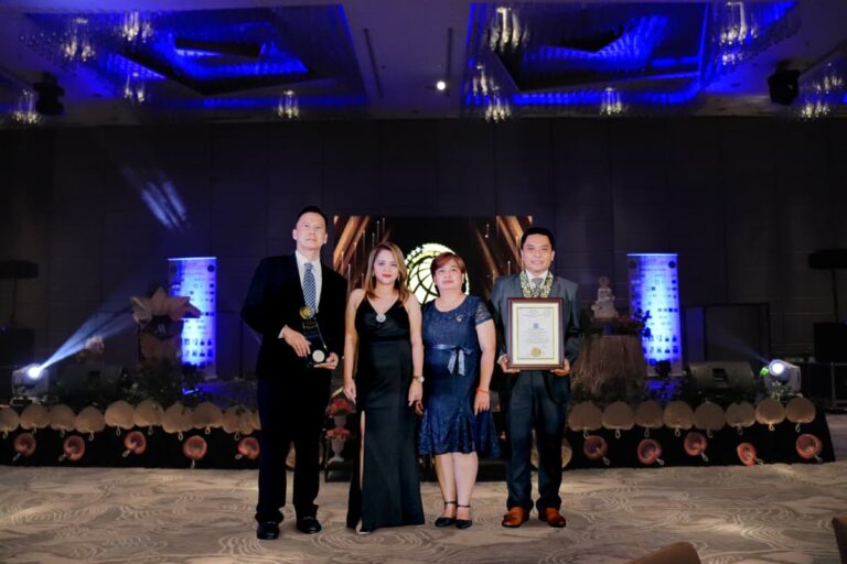 four people holding plaque of awards