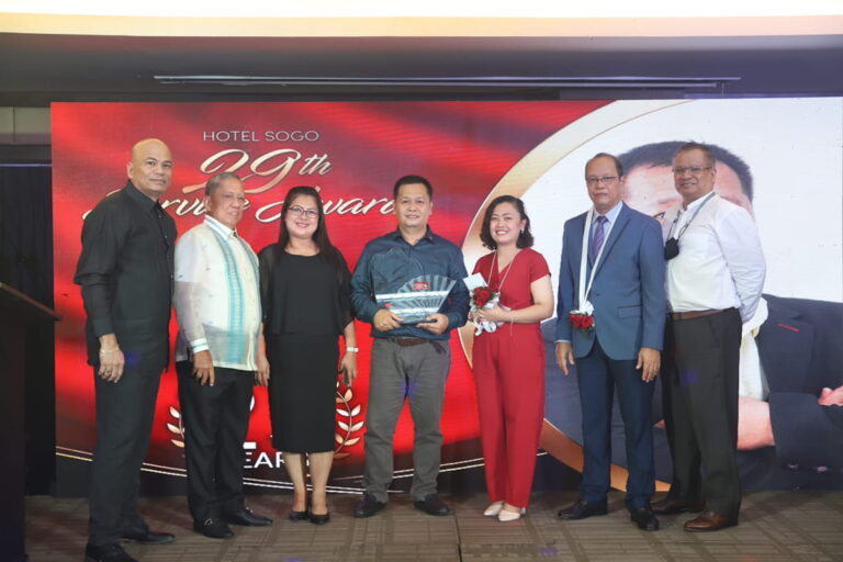 six people holding plaque of awards